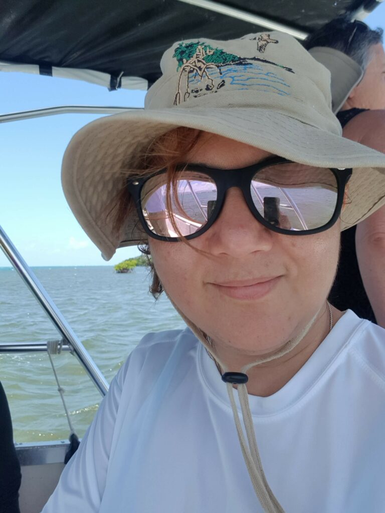 Aitza Pabón Valentin wearing a hat and sunglasses aboard a small boat